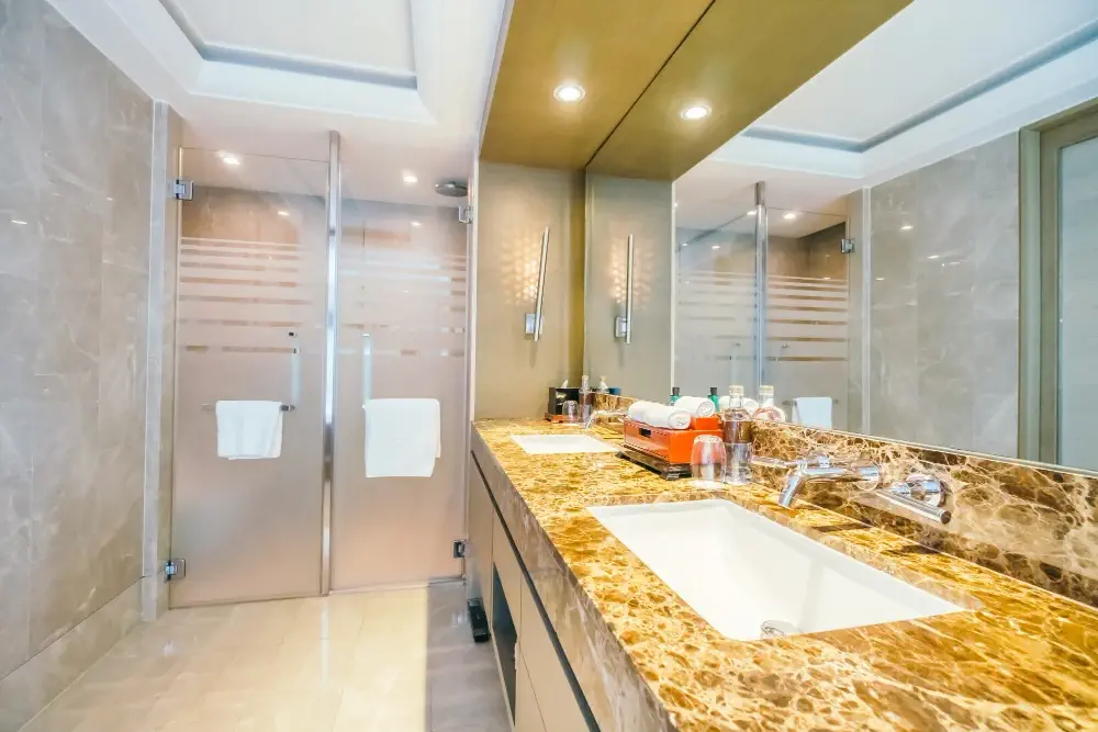 Custom bathroom renovation in Folsom showing a walk-in glass shower enclosure and double vanity tile work